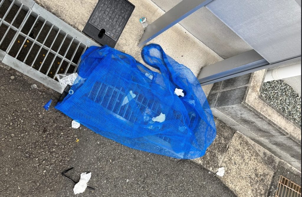 ネットの端をクチバシで器用に持ち上げて侵入されたゴミの画像